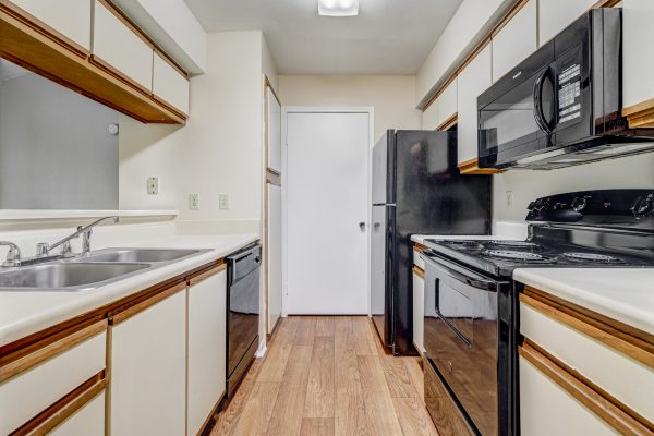 Kitchen with efficient appliances including a refrigerator, built-in microwave, stove, oven, dishwasher, and sink